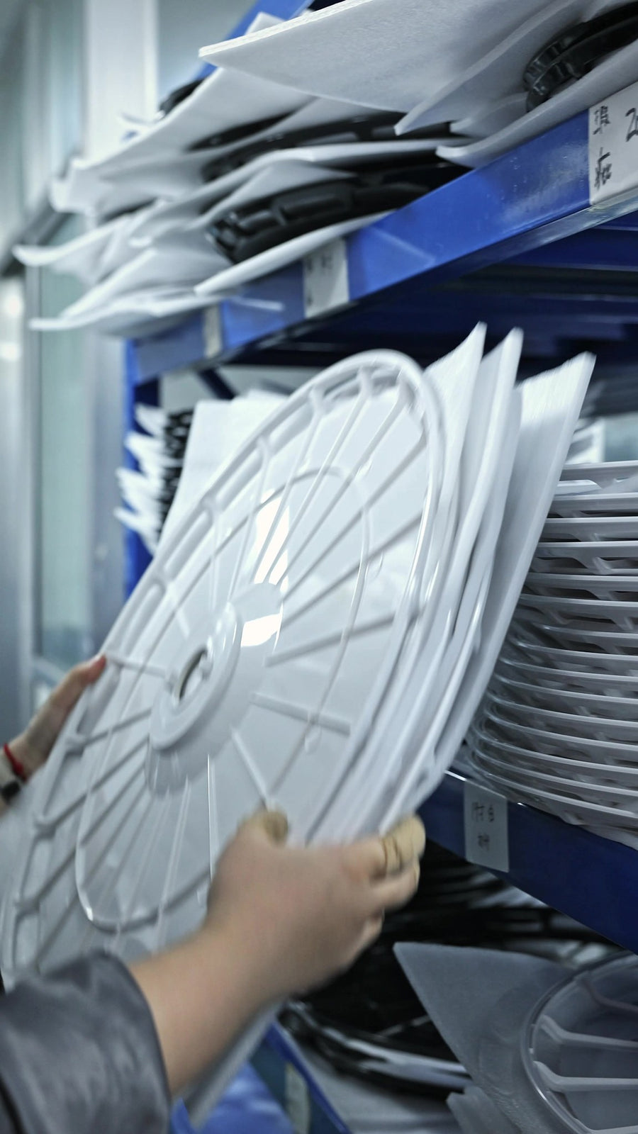 Blank wheel covers racked and labelled by vehicle model