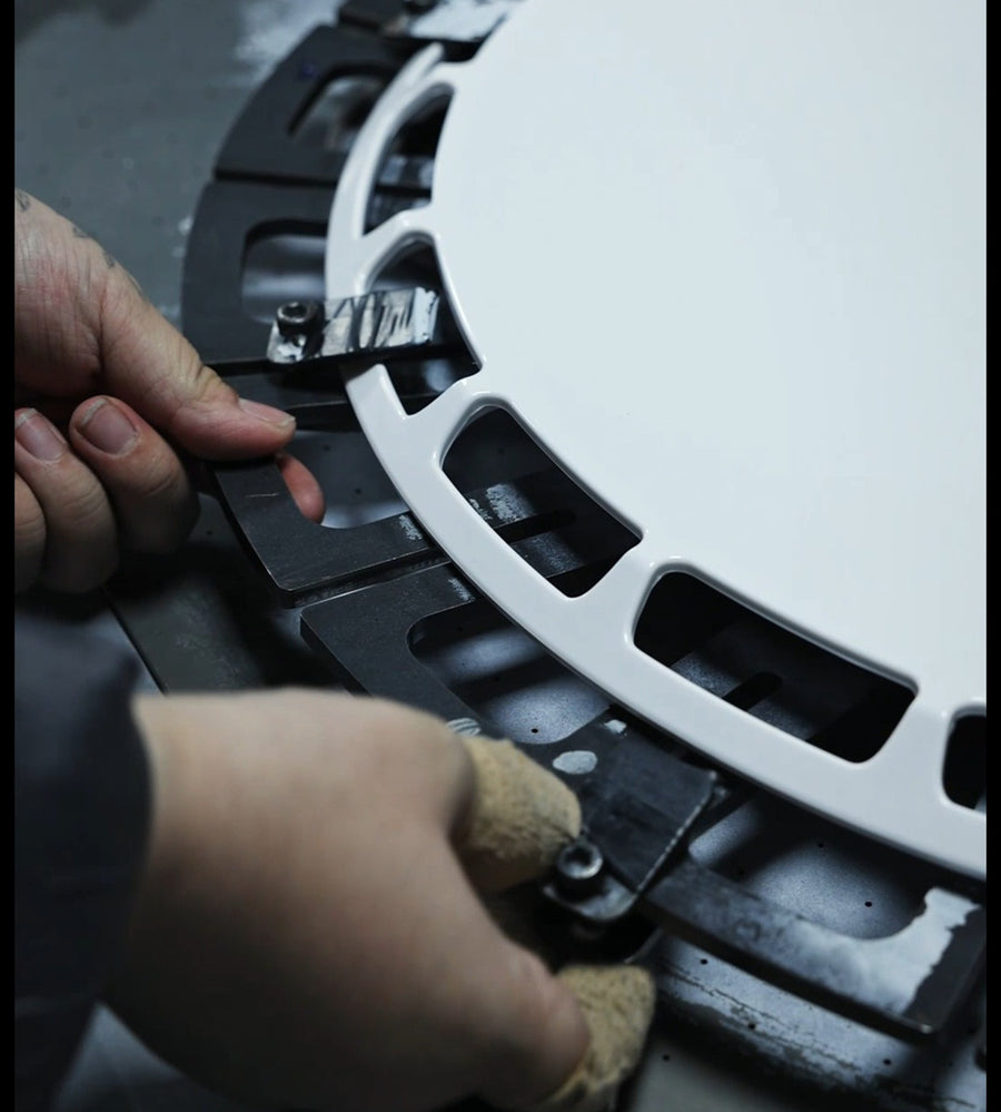 Clamping a wheel cover blank into a model-specific jig